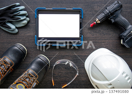 Digital tablet with layout and worker clothes, top view. Digital tablet with layout and worker clothes, top view. 137491080