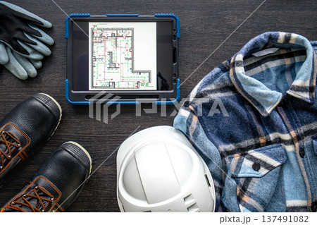 Digital tablet with layout and worker clothes, top view. 137491082
