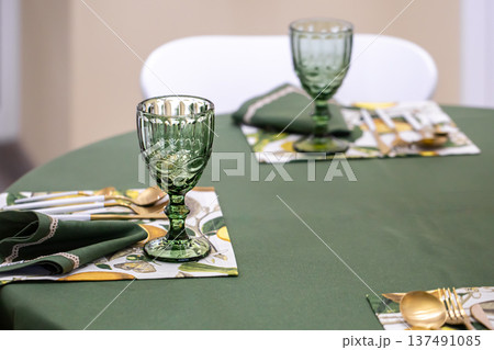 Dinner table setting idea with textured green glass goblets. Dinner table setting idea with textured green glass goblets. 137491085