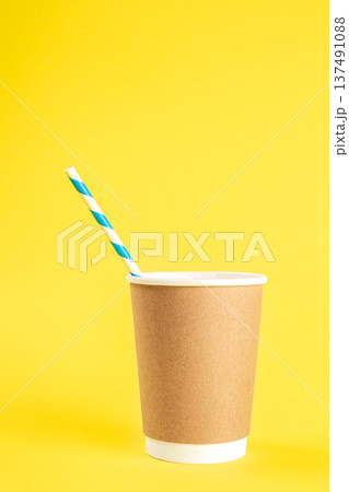 Disposable cup with a straw on a yellow background isolated. 137491088