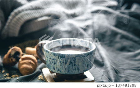 A cup of hot tea and croissants on a blurred background in bed. A cup of hot tea and croissants on a blurred background in bed. 137491209