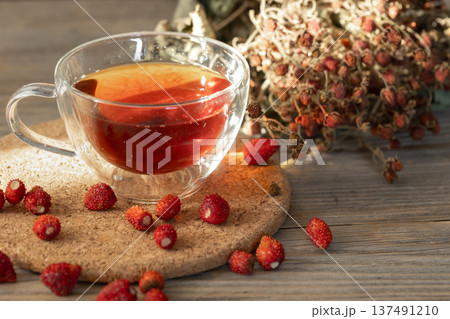 A cup of natural tea and wild strawberries, rustic still life. A cup of natural tea and wild strawberries, rustic still life. 137491210