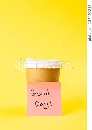 Cup and paper reminder with inscription Good day on a yellow background. 137491215
