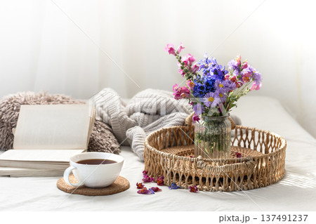 Cup of tea, a bouquet of wildflowers, book and knitted element. Cup of tea, a bouquet of wildflowers, book and knitted element. 137491237