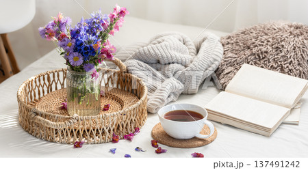 Cup of tea, a bouquet of wildflowers, book and knitted element. Cup of tea, a bouquet of wildflowers, book and knitted element. 137491242