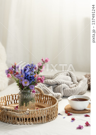 Cup of tea, a bouquet of wildflowers, book and knitted element. 137491244