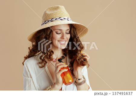 smiling elegant housewife in blouse and shorts on beige smiling elegant housewife in blouse and shorts on beige 137491637