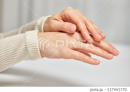 Female hands gently touching each other, symbolizing care and hydration 137491770