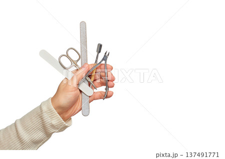 Hand holding a variety of nail care instruments for beauty and grooming Hand holding a variety of nail care instruments for beauty and grooming 137491771
