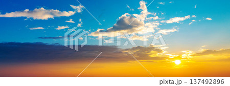 Banner with copy space. A beautiful sunset over a city with a few clouds in the sky Banner with copy space. A beautiful sunset over a city with a few clouds in the sky 137492896