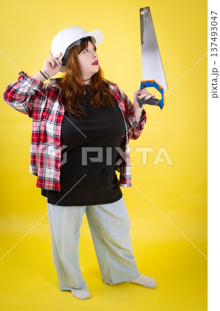 Woman worker thinking while holding hand saw 137493047