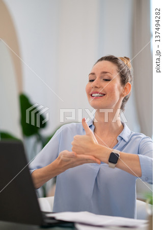 Smiling cute young woman explaining something on video call by sign language 137494282