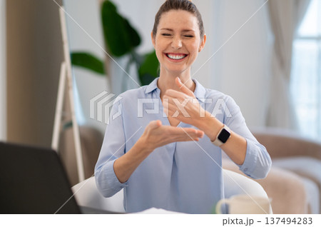 Smiling cute young woman explaining something on video call by sign language 137494283