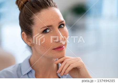 Pretty woman in classic blouse and hair bun looking serious 137494285