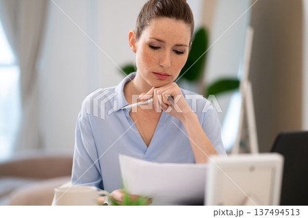 Young business woman looking busy while working from her home office Young business woman looking busy while working from her home office 137494513
