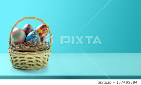 A colorful arrangement of painted Easter eggs nestled in a woven basket filled with straw on a bright turquoise background. Perfect for Easter greeting cards, decorations, or springtime themes 137495394