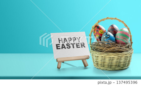 A bright and colorful studio shot featuring a basket full of decorated Easter eggs. Beside the basket is a small easel displaying a sign that reads "Happy Easter" against a soft blue background 137495396