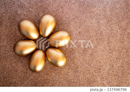 Six golden eggs arranged like a flower on a glittering gold background for luxury celebration Six golden eggs arranged like a flower on a glittering gold background for luxury celebration 137496796