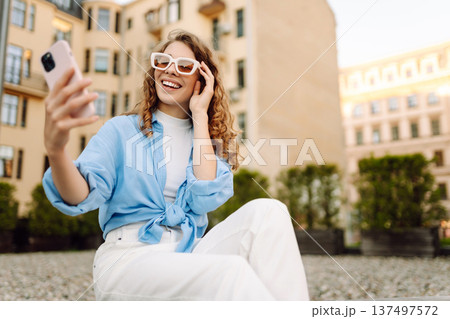 Beautiful woman traveler using phone, taking selfie, walking on the old town street. Blogging Beautiful woman traveler using phone, taking selfie, walking on the old town street. Blogging 137497572