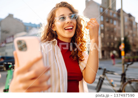 Happy woman tourist with phone. Young woman writing text for sharing content about vacations Happy woman tourist with phone. Young woman writing text for sharing content about vacations 137497590