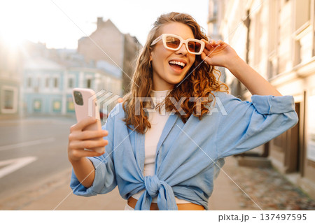 Portrait happy woman walking with phone in city. Online Communication with friend. Lifestyle concept 137497595