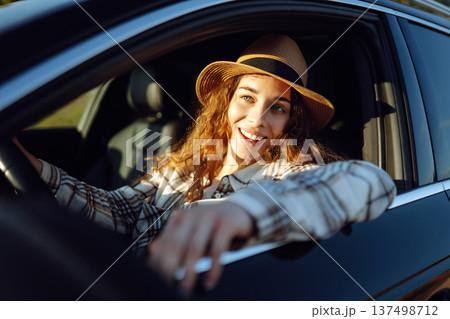 Beautiful young woman driving her car. Woman traveler. Summer vacation and adventure. Beautiful young woman driving her car. Woman traveler. Summer vacation and adventure. 137498712
