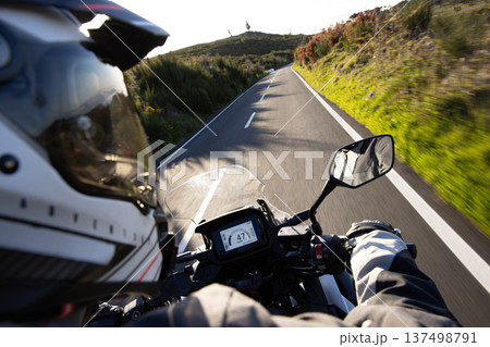Driver riding motorcycle on empty asphalt road, handlebars view , spring mountains 137498791