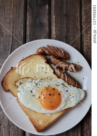 目玉焼きを乗せたトーストと粗挽きウインナー 目玉焼きを乗せたトーストと粗挽きウインナー 137498891