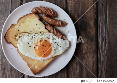 目玉焼きを乗せたトーストと粗挽きウインナー 目玉焼きを乗せたトーストと粗挽きウインナー 137498892