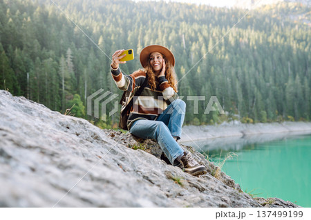 Happy tourist woman taking picture outdoors for memories. Selfie time. Lifestyle, active life. 137499199