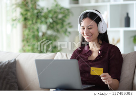 Happy asian woman buying media online at home 137499398