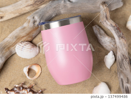 Wine tumbler mockup with blank white 12oz stainless steel cup on sand with seashells and driftwood Wine tumbler mockup with blank white 12oz stainless steel cup on sand with seashells and driftwood 137499486