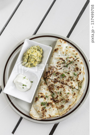 cheese quesadilla plate with guacamole and sour cream on white restaurant table in mexico cheese quesadilla plate with guacamole and sour cream on white restaurant table in mexico 137499708