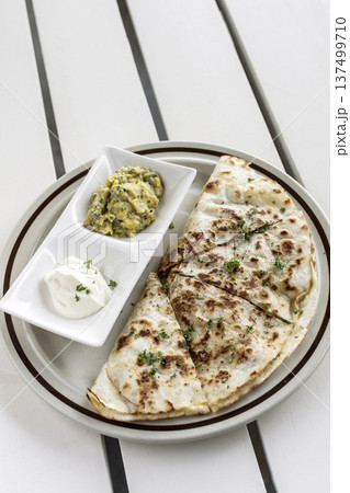cheese quesadilla plate with guacamole and sour cream on white restaurant table in mexico 137499710