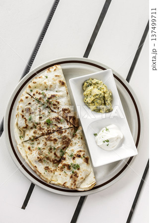 cheese quesadilla plate with guacamole and sour cream on white restaurant table in mexico cheese quesadilla plate with guacamole and sour cream on white restaurant table in mexico 137499711