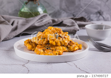 Delicious corn fritters with herbs on a plate on the table Delicious corn fritters with herbs on a plate on the table 137499727