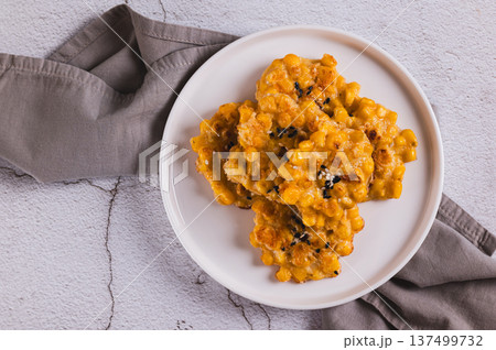 Close up of delicious corn fritters with herbs on a plate on the table top view 137499732