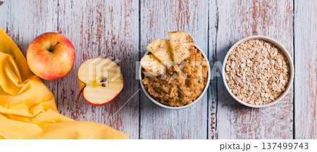 Oatmeal with apple baked in a bowl on the table top view web banner 137499743