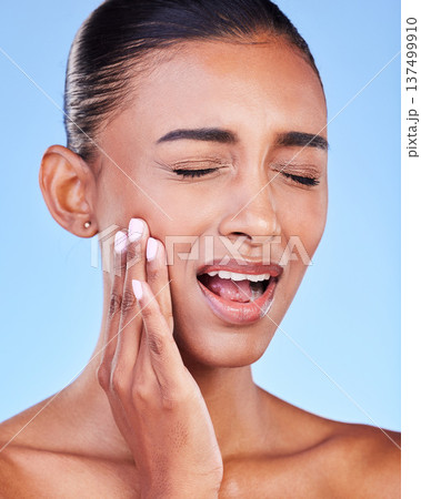 Toothache, cavity and a woman with mouth pain on a blue background with a dental emergency. Sad, accident and a girl with problem with a teeth injury, gingivitis or inflammation of a gum Toothache, cavity and a woman with mouth pain on a blue background with a dental emergency. Sad, accident and a girl with problem with a teeth injury, gingivitis or inflammation of a gum 137499910
