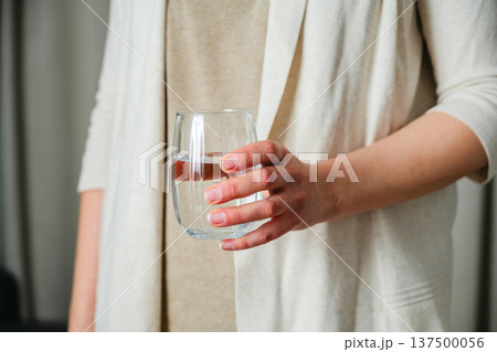 Woman holding a glass of clear water. Healthy lifestyle, beauty skin health care concept Woman holding a glass of clear water. Healthy lifestyle, beauty skin health care concept 137500056