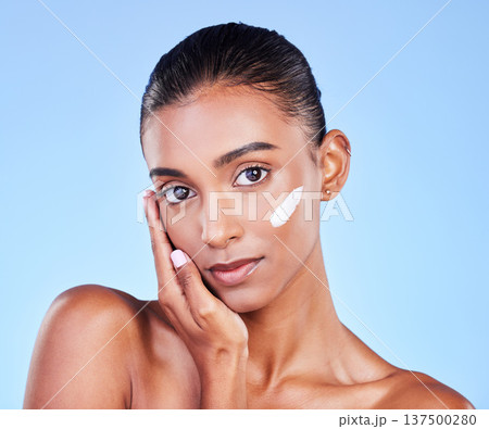 Skincare, cream and health with face of woman in studio for beauty, facial or moisturizer. Spa treatment, lotion and collagen with portrait of person on blue background for makeup, glow or sunscreen Skincare, cream and health with face of woman in studio for beauty, facial or moisturizer. Spa treatment, lotion and collagen with portrait of person on blue background for makeup, glow or sunscreen 137500280