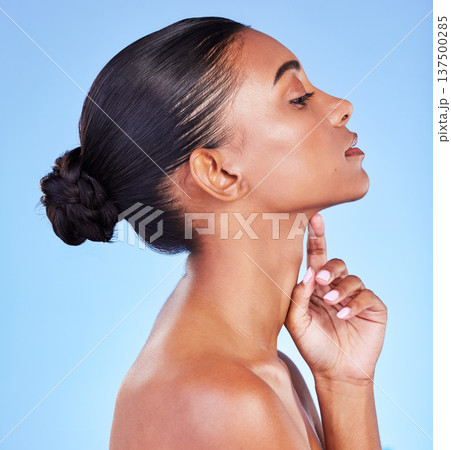 Woman, skin and profile of natural beauty, skincare or shine from cosmetics on blue background in studio with calm model. Dermatology, facial and healthy glow from makeup or wellness from self care Woman, skin and profile of natural beauty, skincare or shine from cosmetics on blue background in studio with calm model. Dermatology, facial and healthy glow from makeup or wellness from self care 137500285
