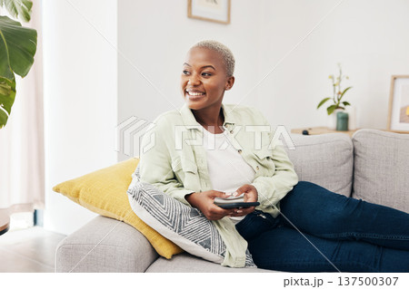 Woman, happy and thinking with phone on sofa to relax with social media, digital contact and user connection. African person, smartphone and idea for mobile blog, search subscription and app at home 137500307