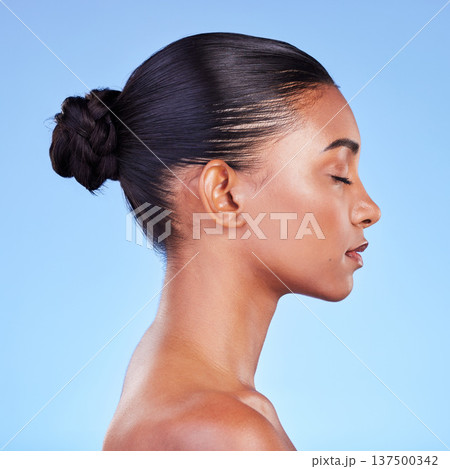 Woman, skincare and profile of natural beauty or shine on skin from cosmetics on blue background in studio with calm model. Dermatology, facial and healthy glow from makeup, wellness or self care 137500342
