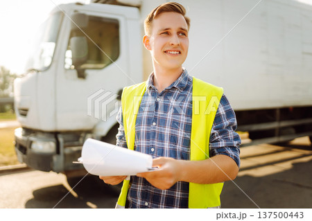 Portrait of truck driver in casual clothes standing in front of truck vehicles. Transport industry. Portrait of truck driver in casual clothes standing in front of truck vehicles. Transport industry. 137500443