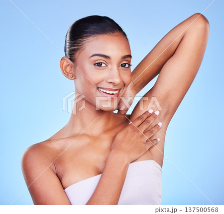 Woman touching armpit in portrait, hair removal and beauty, grooming and smile isolated on blue background. Hygiene, cleaning body and epilation with skincare, cosmetics and dermatology in a studio Woman touching armpit in portrait, hair removal and beauty, grooming and smile isolated on blue background. Hygiene, cleaning body and epilation with skincare, cosmetics and dermatology in a studio 137500568