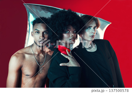 Queer, diversity and portrait of people in fashion with creative black woman, gay man and model on red background in studio. Lgbt, friends and beauty for edgy, aesthetic or unique makeup and clothes 137500578