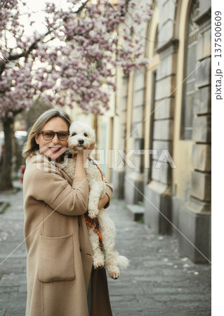 Woman Hugging Dog with Cherry Blossoms in Background 137500609