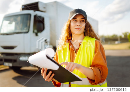 Portrait of woman truck driver in casual clothes standing in front of truck. Transport industry 137500613