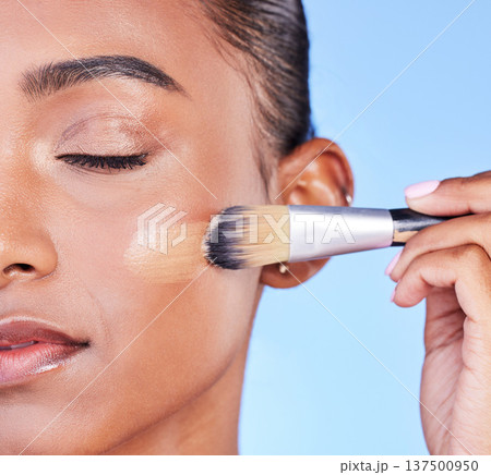 Face, brush and foundation, woman and makeup with beauty closeup isolated on blue background. Cosmetic product, application and cosmetology, skin glow and wellness, powder and self care in studio Face, brush and foundation, woman and makeup with beauty closeup isolated on blue background. Cosmetic product, application and cosmetology, skin glow and wellness, powder and self care in studio 137500950
